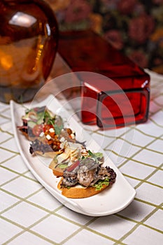 assorted bruschetta on a white plate on the table
