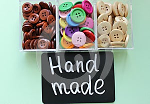 Assorted buttons and chalk Board with the inscription ` handmade`