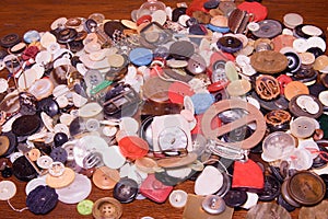 Assorted buttons. Different in color, mostly plastic, some wooden. Pile of buttons close up background.