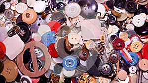 Assorted buttons. Different in color, mostly plastic, some wooden. Pile of buttons close up background.