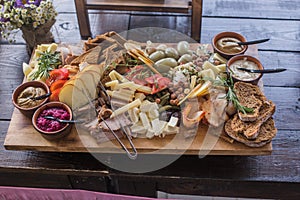 Assorted cheese cured meat, sausage, ham, fruits, vegetables, olives, pickled, bread and sauce for the event or party