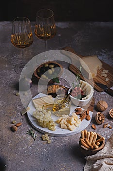 Assorted cheeses on marble plate with figs, nuts, grapes and honey