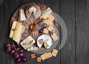 Assorted cheeses on round wooden board plate