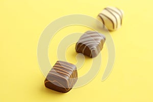 Assorted chocolate bonbons on a yellow surface