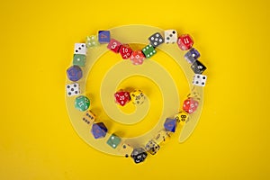 Assorted color and dice in a heart shape on yellow background
