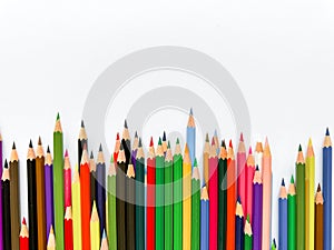 Assorted colored pencils lined up on white background with space for text. Creative concept for art, education, and
