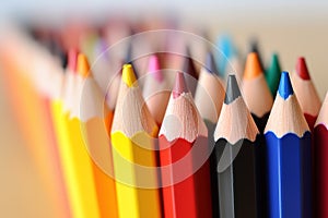 Assorted colored pencils in a row, closeup, School supplies.