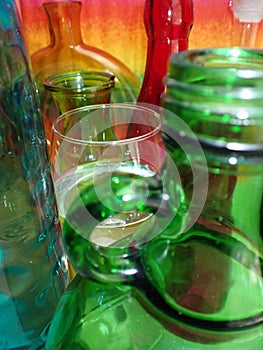 assorted colorful bottles, wine glass in the middle. Collage
