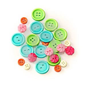 Assorted colorful craft buttons over white