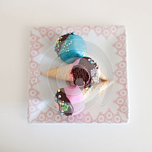 Assorted colorful cupcakes in ice cream cones