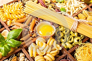 Assorted colorful italian pasta in wooden box