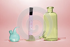 Assorted colorful laboratory glassware on red stained background