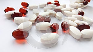 Assorted colorful pharmaceutical medicine pills, tablets and capsules with bottle on white background