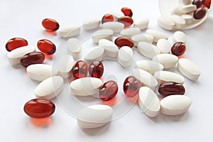 Assorted colorful pharmaceutical medicine pills, tablets and capsules with bottle on white background