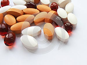 Assorted colorful pharmaceutical medicine pills, tablets and capsules on white background