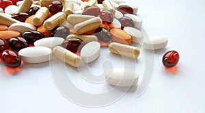 Assorted colorful pharmaceutical medicine pills, tablets and capsules on white background