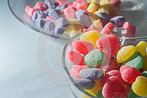 Assorted colorful sweets in a trasparente bowl, light blue background, children's concept and joy photo