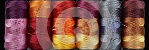 Assorted cotton threads on spools for sewing and embroidery projects in vibrant colors