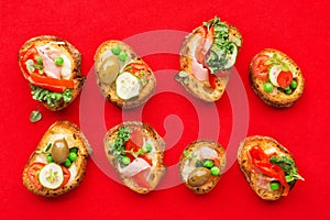 Assorted crostini canapes with cottage cheese, baked capsicum, cucumber slices, bacon, tomatoes, green peas on a festive