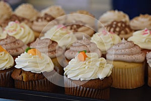 Assorted Cupcakes with frosting and decorations on display at bakery