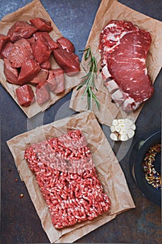 Assorted cuts of raw angus beef meat on parchment paper