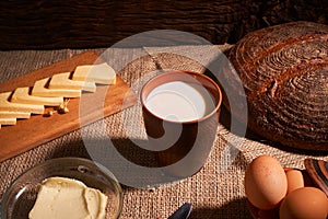 Assorted dairy products milk, cheese, butter rustic still life on table