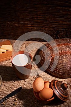 Assorted dairy products milk, cheese, eggs. rustic still life on table