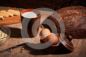 Assorted dairy products milk, cheese, eggs. rustic still life on table