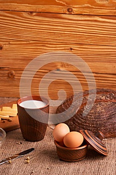 Assorted dairy products milk, cheese, eggs. rustic still life on table