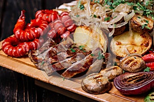 Assorted delicious grilled meat, sausages and vegetables on cutt