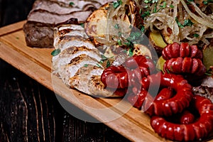 Assorted delicious grilled meat, sausages and vegetables on cutt