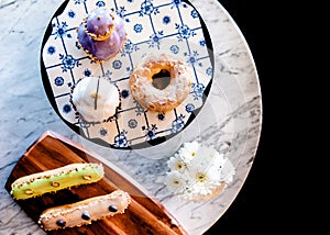 Assorted dessert on white mable table, donut, cup cake, eclaire