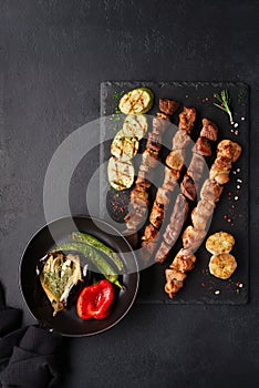 Assorted different kebabs on a black stone plate