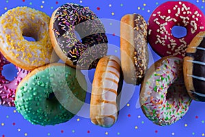 Assorted of donuts with chocolate frosted, pink glazed and other kind of sprinkled.