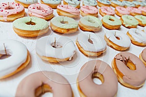 Assorted donuts with chocolate frosted, pink glazed and sprinkles donuts.