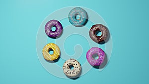 Assorted donuts with colorful icings on blue background.