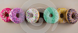 Assorted of doughnuts with different kinds of topping on light background.