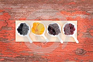 Assorted dried berries and fruit in ramekins photo