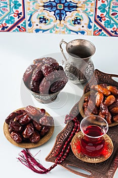 Assorted dried dates or kurma served on a vintage plates and tea