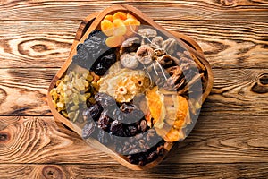 Assorted dried fruits wooden bowl, top view. organic food background