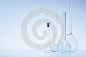 Assorted empty laboratory glassware, test-tubes. Blue tone medical background. Copy space