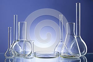 Assorted empty laboratory glassware, test-tubes. Blue tone medical background. Copy space