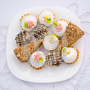 Assorted fancy gourmet cupcakes on a plate.