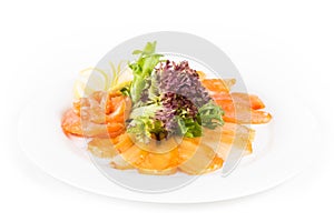 Assorted fish on a plate with lettuce and lemon on a white background. A plate of fish assorted isolated