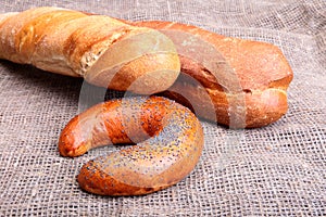 Assorted fresh breads isolated on old sackcloth.