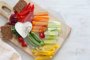 Assorted fresh chopped vegetables with dip on ligt background, tasty and healthy snack