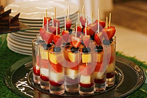 Assorted fresh fruits on a skewer in a glass