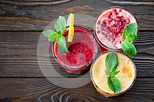 Assorted fruit smoothies on a wooden table