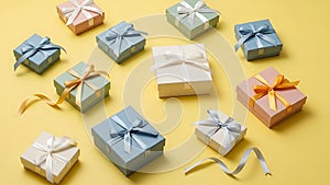 Assorted gift boxes with ribbons on yellow background