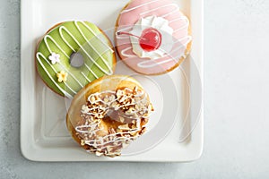 Assorted glazed fried donuts on a plate